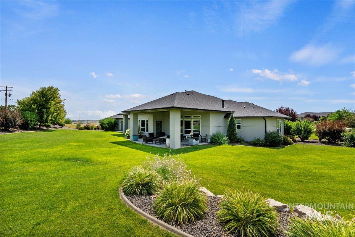 15465 Syrah Court Caldwell, ID 83607 - Photo 35 of 50 Back of house featuring a patio, a yard, and stucco siding