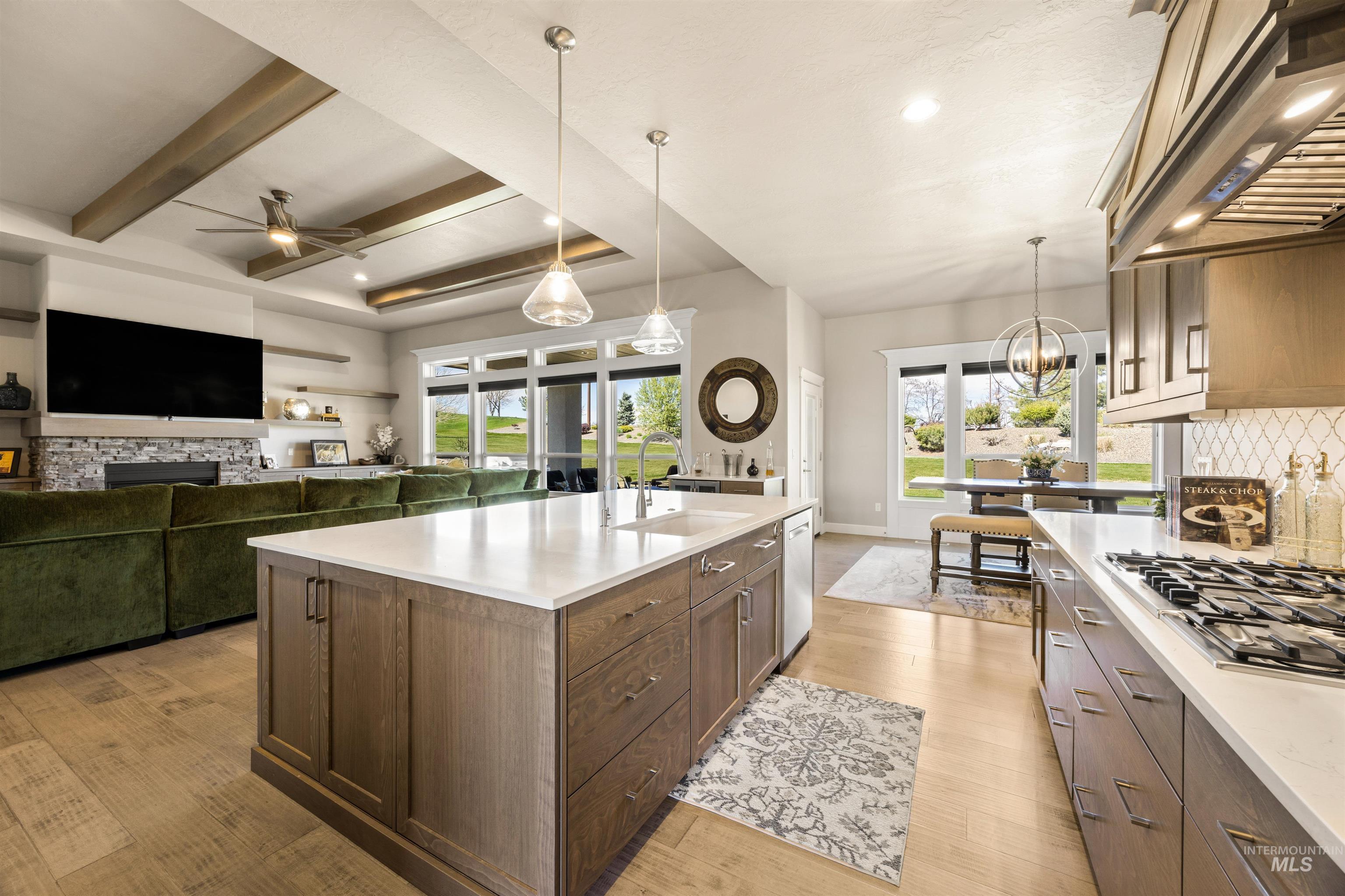 15465 Syrah Court Caldwell, ID 83607 - Photo 43 of 45 Kitchen with ventilation hood, open floor plan, light wood-style flooring, stainless steel gas cooktop, and beam ceiling