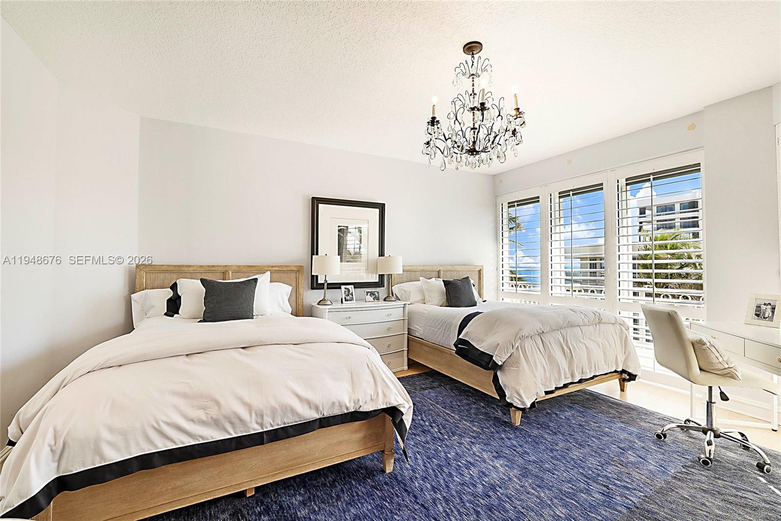 19950 South Beach Road, Unit 4S Jupiter, FL 33469 - Photo 14 of 56 a bedroom with bed and a chandelier