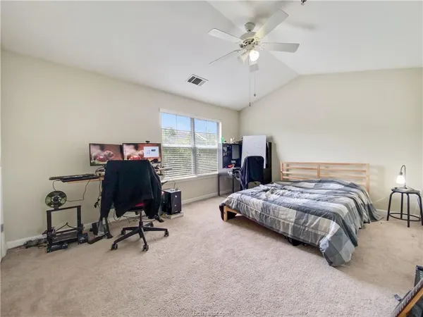 a bedroom with bed a desk and chair