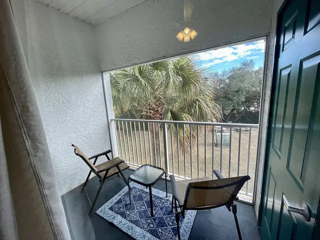 a view of a porch with furniture and wooden floor