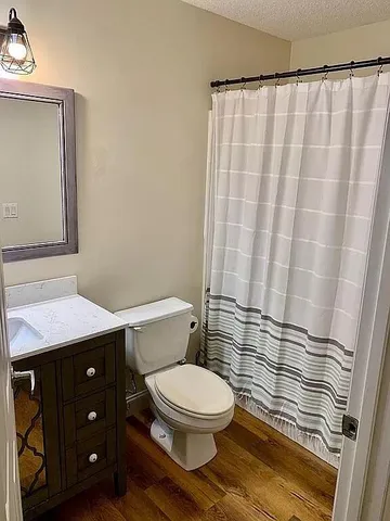a bathroom with a granite countertop toilet and a sink