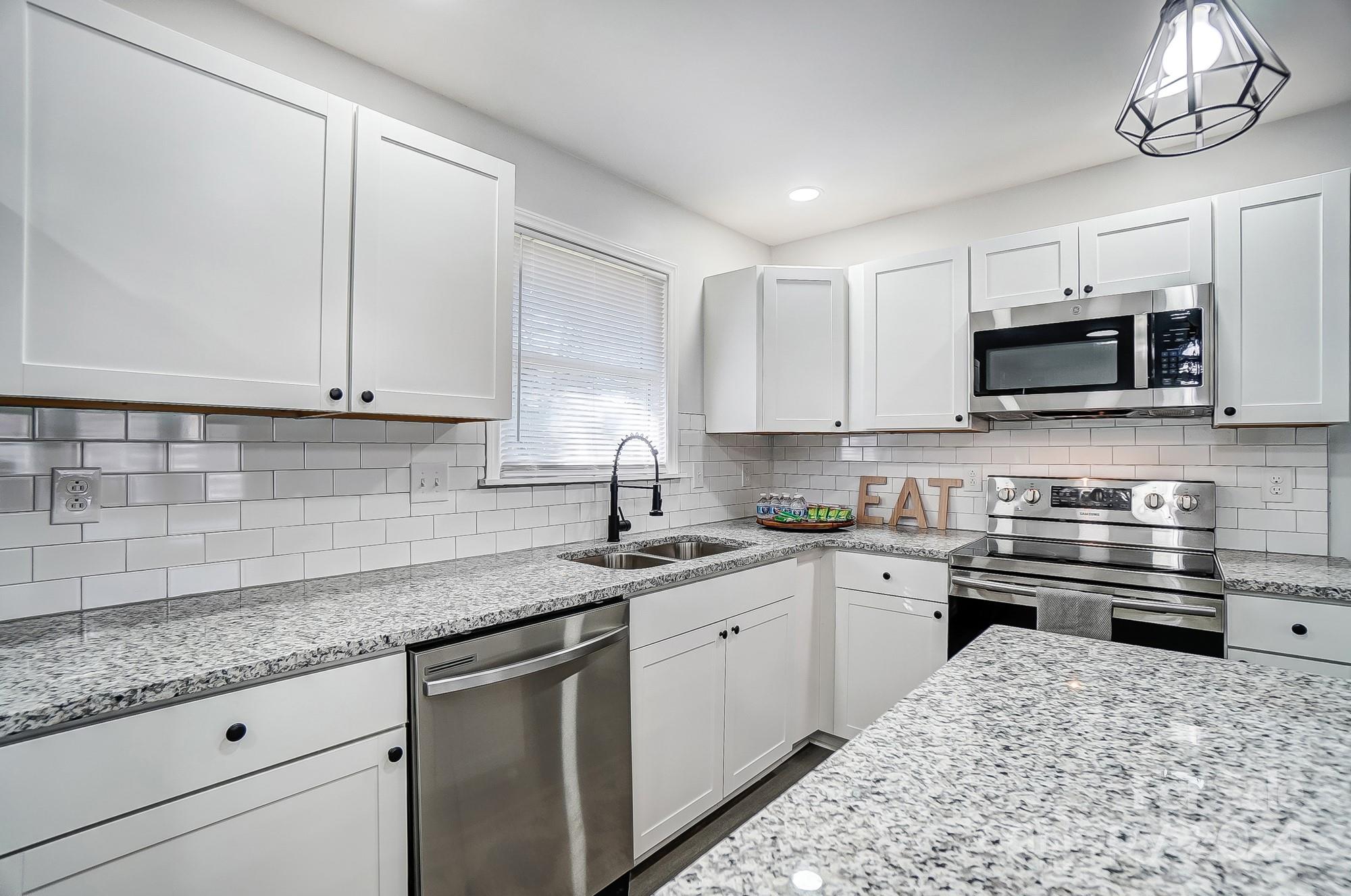 6524 Eaglecrest Road Charlotte, NC 28212 - Photo 13 of 48 a kitchen with stainless steel appliances granite countertop a sink and a stove