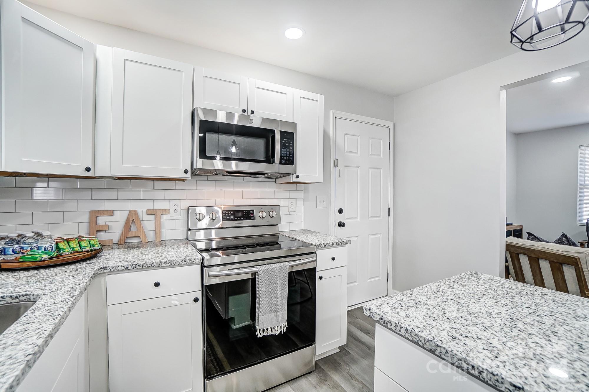 6524 Eaglecrest Road Charlotte, NC 28212 - Photo 14 of 48 a kitchen with granite countertop a sink stove and microwave