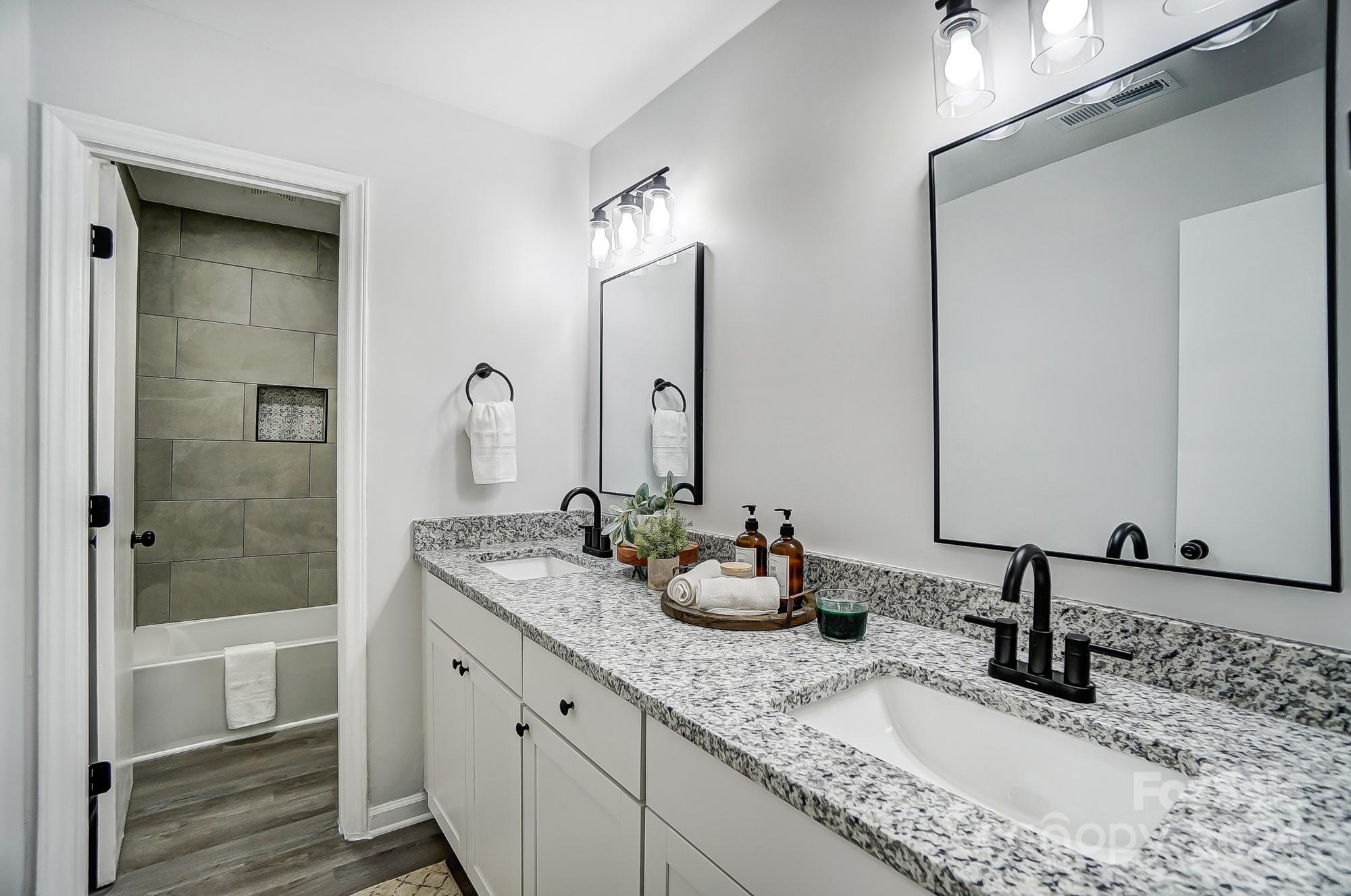 6524 Eaglecrest Road Charlotte, NC 28212 - Photo 23 of 48 a bathroom with double sink and a mirror