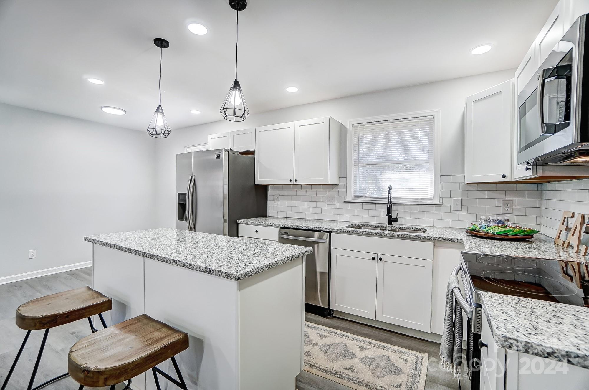6524 Eaglecrest Road Charlotte, NC 28212 - Photo 10 of 48 a kitchen with a stove a sink a dining table and chairs