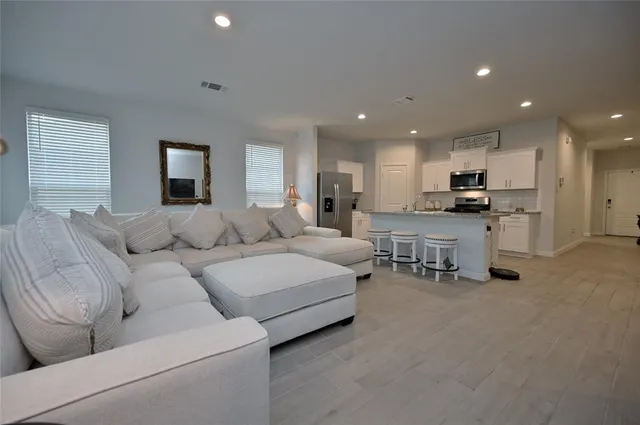 a living room with furniture and kitchen