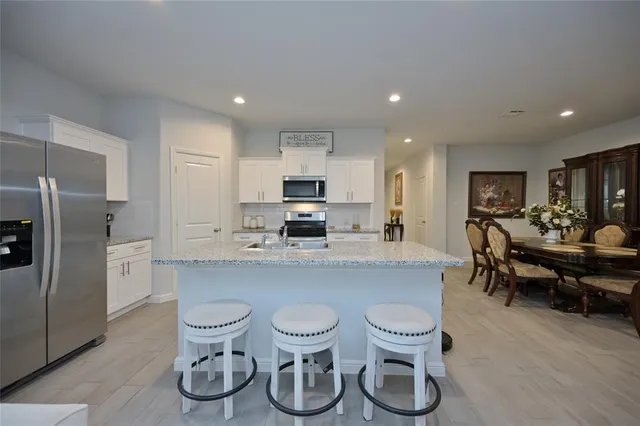 a kitchen with a sink and chairs