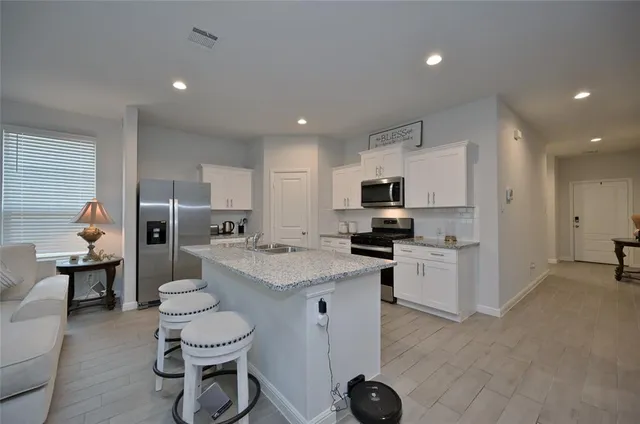 a open kitchen with stainless steel appliances kitchen island granite countertop a sink and cabinets