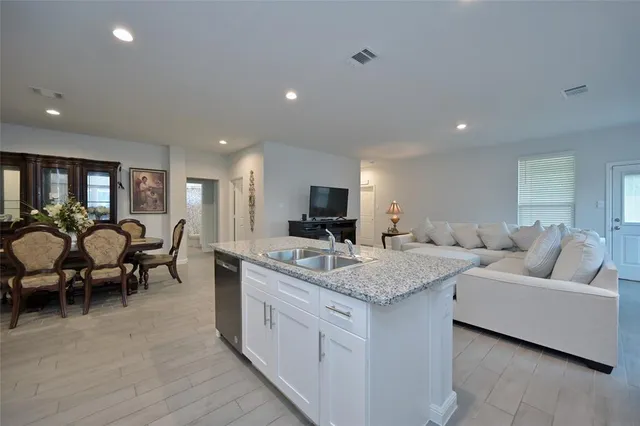 a living room with furniture kitchen view and a flat screen tv