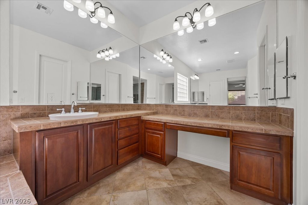 2125 De Rouge Avenue Henderson, NV 89044 - Photo 47 of 96 Ample counter space and a large mirror illuminate this functional and stylish bathroom vanity.