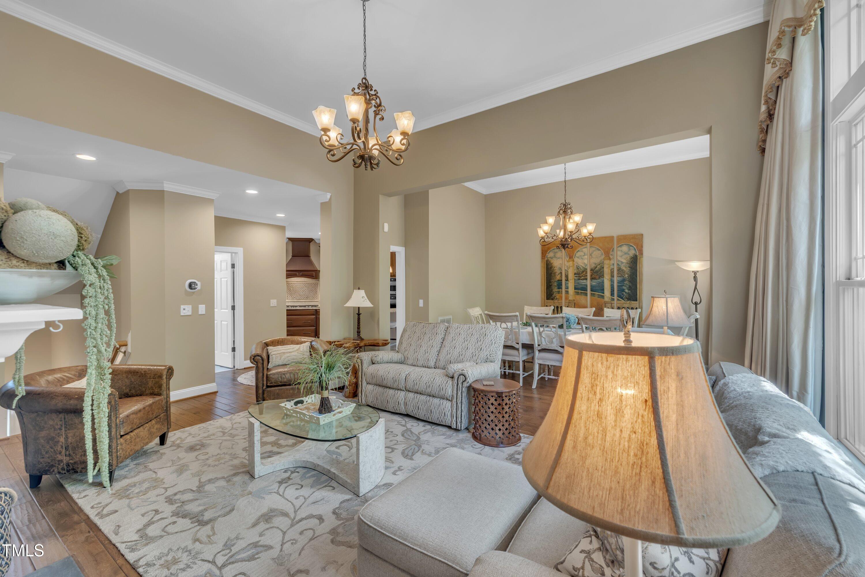 4802 Glenmist Court Raleigh, NC 27612 - Photo 15 of 52 a large living room with a large chandelier and chandelier