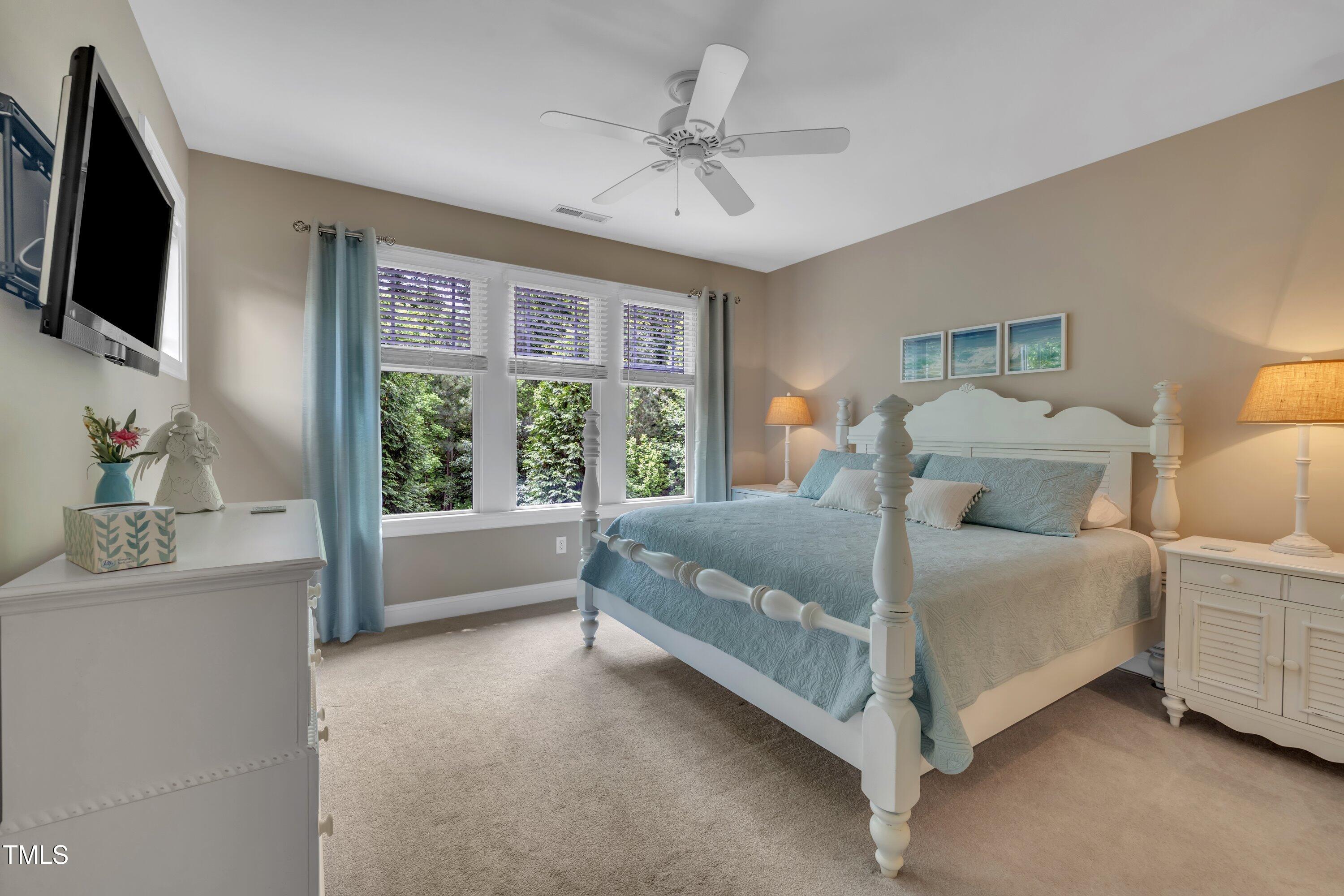 4802 Glenmist Court Raleigh, NC 27612 - Photo 32 of 52 a bedroom with a bed a window and a flat screen television