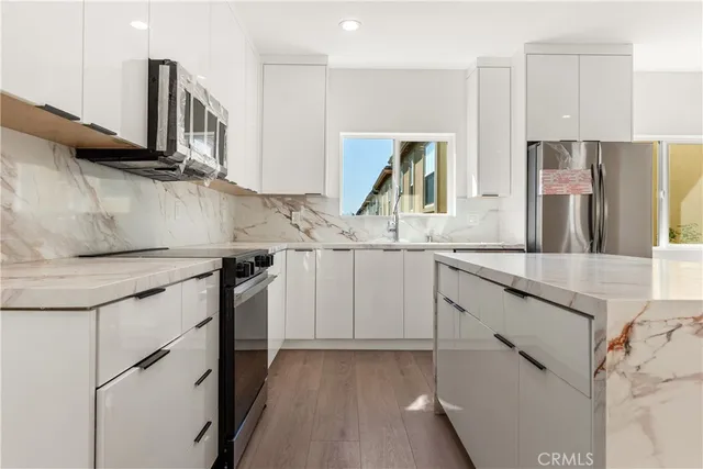 a kitchen with stainless steel appliances granite countertop a sink and a stove