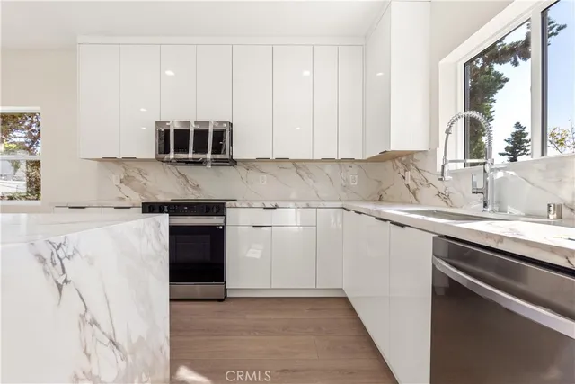 a kitchen with stainless steel appliances granite countertop a sink and a stove