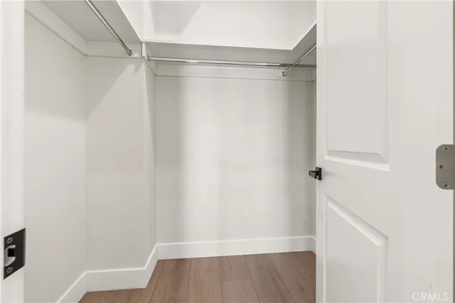 a view of walk in closet with wooden floor