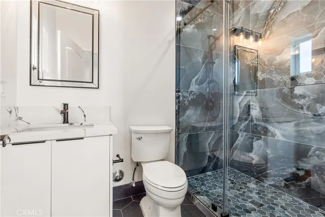 a bathroom with a granite countertop sink toilet and a mirror
