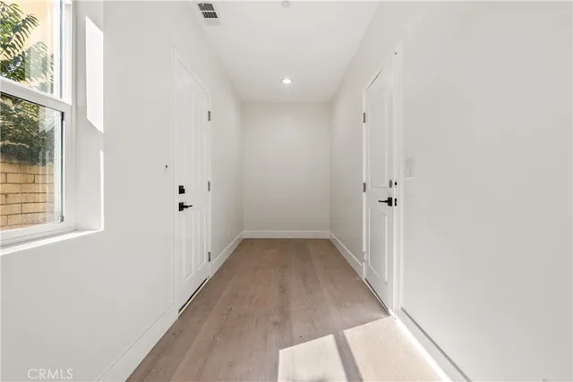 a view of a hallway with wooden floor