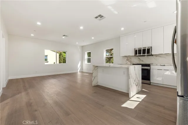a kitchen with stainless steel appliances granite countertop a stove a sink and a refrigerator