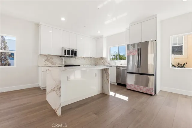 a kitchen with stainless steel appliances a refrigerator sink and microwave
