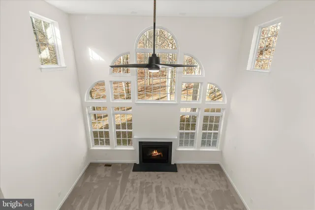 a view of an empty room with a fireplace and a window