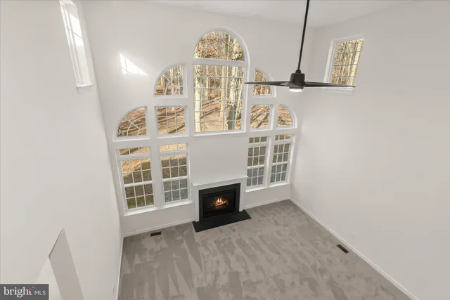 a view of an empty room with a fireplace and a window