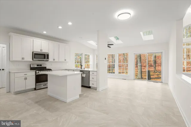 a view of a room with wooden floor chandelier and windows