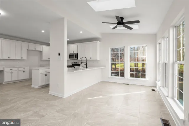 a view of a livingroom with wooden floor and a ceiling fan