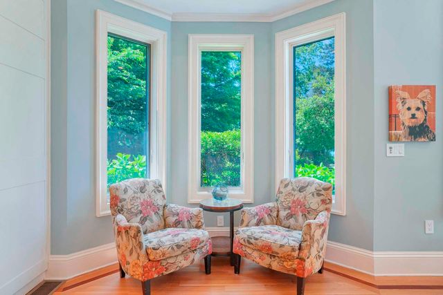 a view of a dining room and livingroom with furniture wooden floor a chandelier