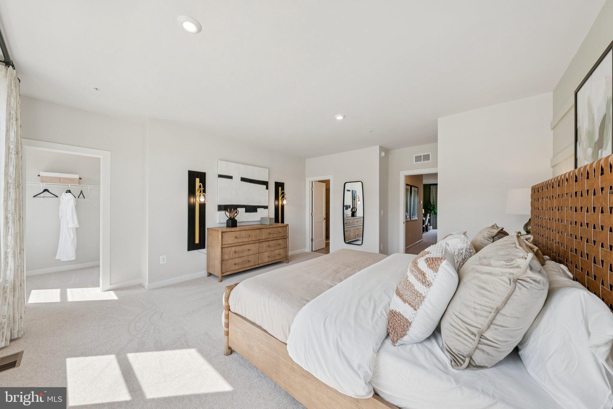 13715 Cobble Loop Woodbridge, VA 22193 - Photo 20 of 29 a spacious bedroom with a bed a table and painting on the wall