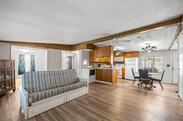 a kitchen with a dining table chairs stainless steel appliances and cabinets