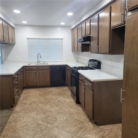 a large kitchen with stainless steel appliances granite countertop a sink and cabinets