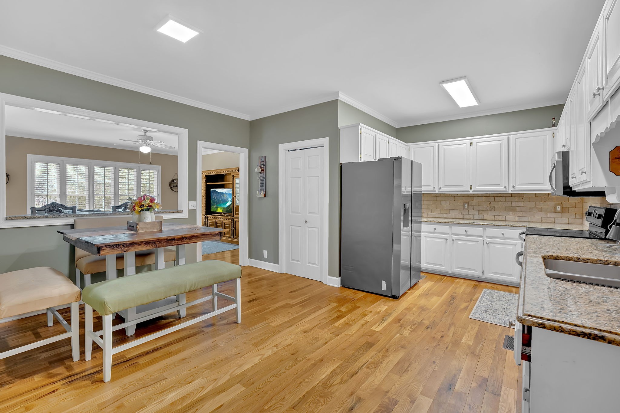 2115 Battleground Drive Murfreesboro, TN 37129 - Photo 12 of 40 a kitchen with stainless steel appliances kitchen island granite countertop a refrigerator a stove a sink dishwasher and white cabinets with wooden floor