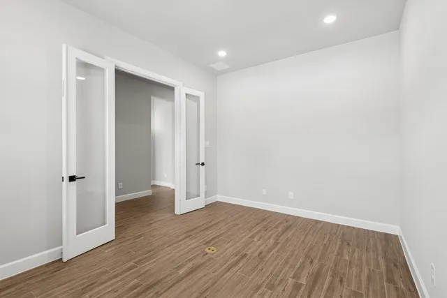 a view of an empty room with wooden floor