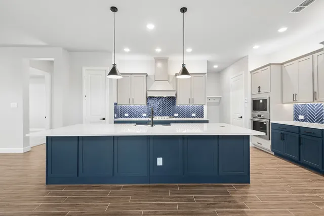 a large kitchen with stainless steel appliances kitchen island granite countertop a large island in the center