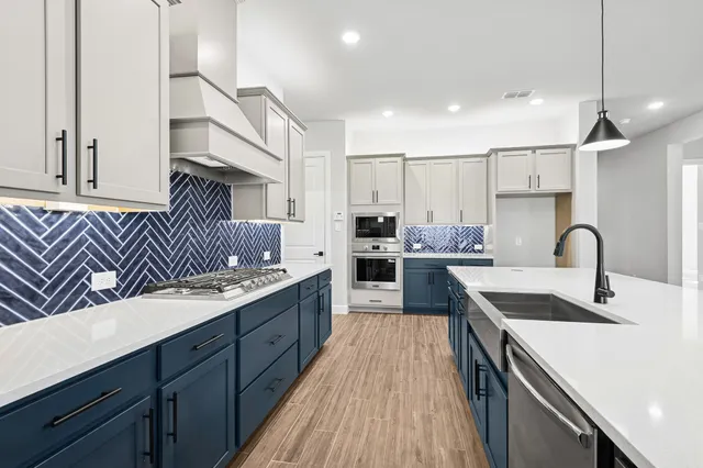 a kitchen with granite countertop a sink stainless steel appliances and cabinets