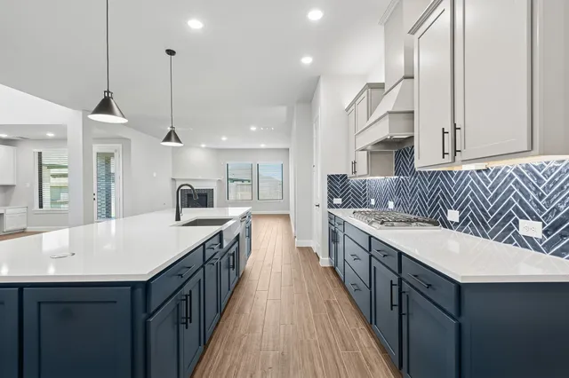 a kitchen with kitchen island a sink and a stove