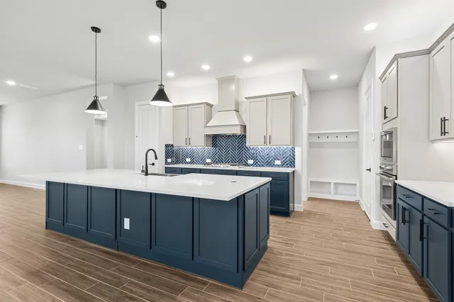 a large kitchen with a sink and cabinets
