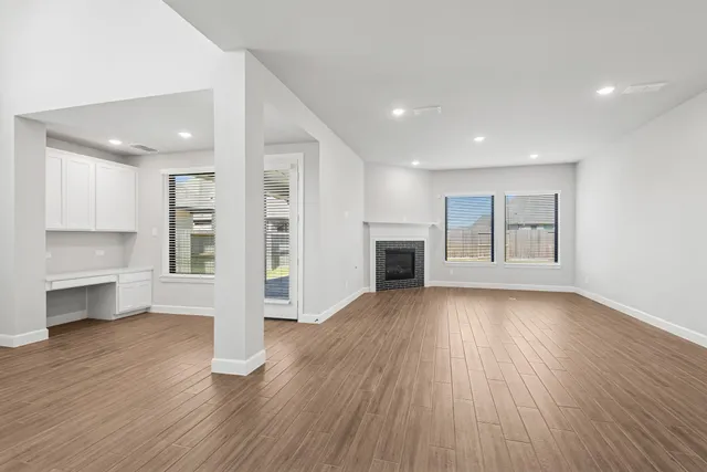a view of a big room with wooden floor and a fireplace