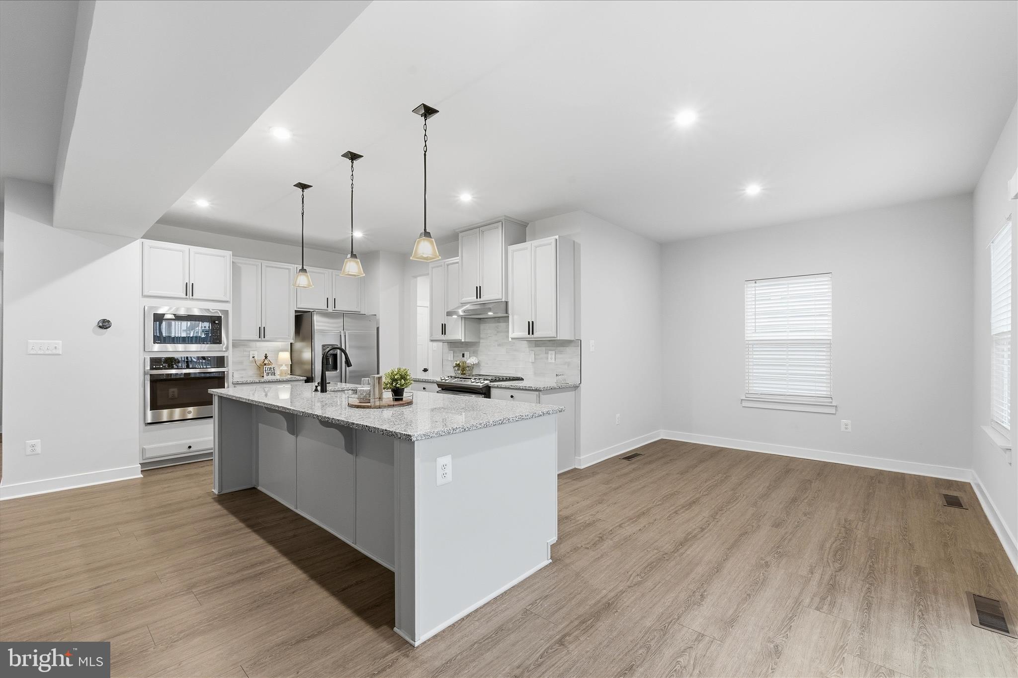 516 Rushbrook Road Martinsburg, WV 25403 - Photo 23 of 86 a kitchen with stainless steel appliances kitchen island hardwood floor sink and stove