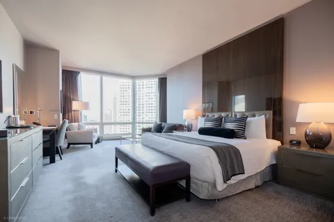 a spacious bedroom with a bed couch and a large window