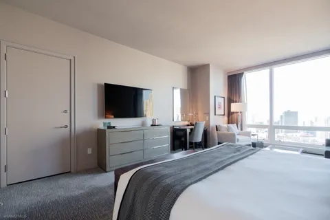 a bedroom with a bed and a flat screen tv