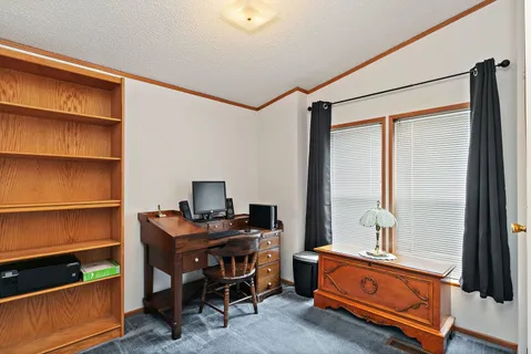 a view of a workspace with furniture and a window