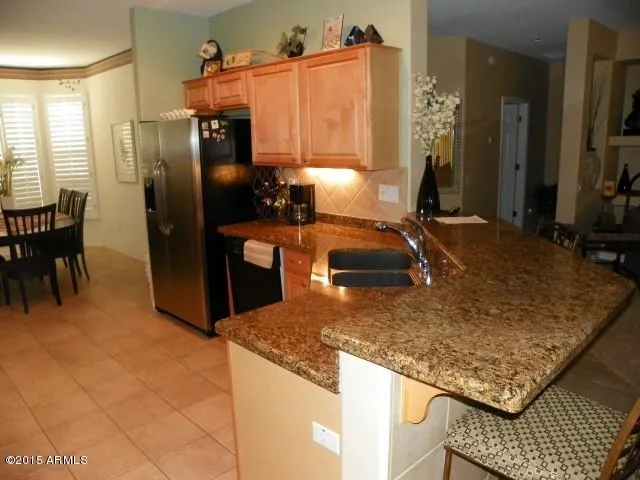 a kitchen with stainless steel appliances granite countertop a sink and a refrigerator