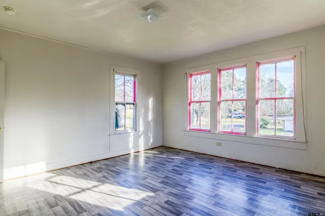 a view of empty room with wooden floor
