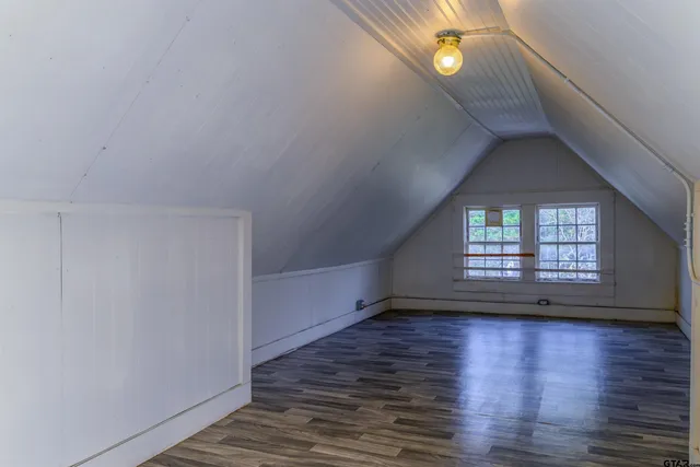 a view of a hallway view with wooden floor and a bathroom