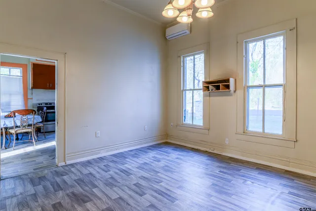 a view of an empty room with wooden floor