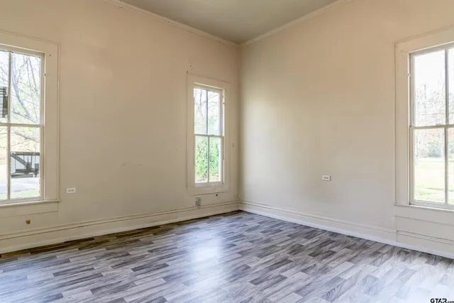 an empty room with wooden floor and window