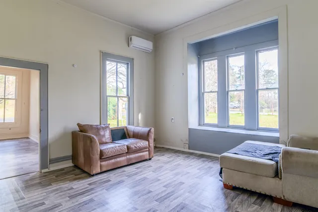 a view of an empty room with wooden floor and closet