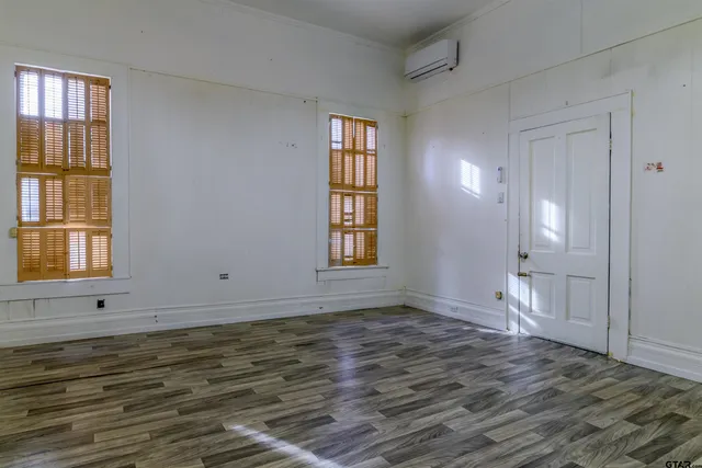 a view of a livingroom with wooden floor and a hallway